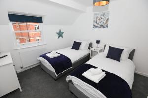 埃克斯茅斯Strand House Flat 2 Free Parking, by RentMyHouse的一间卧室设有两张床和窗户。