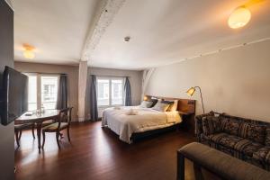 根特B&B Kwaadham 52 - Music Hotel Ghent的一间卧室配有一张床、一张桌子和一张沙发