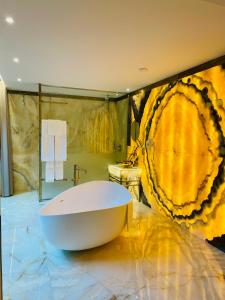 查韦斯Castelo Hotel的一间带大浴缸和大画的浴室