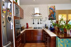 伊维萨镇Villa Can Blau Ibiza的厨房配有木制橱柜和冰箱。