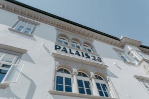 菲拉赫Hotel Palais26的白色的建筑,旁边标有标志