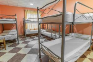 TorremegíaAlbergue Rojo Plata的客房设有三张双层床和一张可拼接的地板。