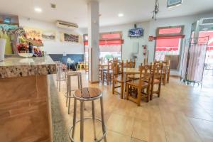 TorremegíaAlbergue Rojo Plata的一间带桌椅的餐厅和一间酒吧