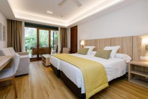 阿尔库迪亚波伦蒂亚蓝色港湾俱乐部Spa度假酒店的酒店客房设有一张大床和一张书桌。