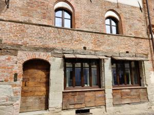 皮内罗洛Domus Acaja的旧砖砌的建筑,设有门窗