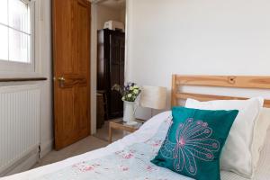 伦敦Hampstead 19th Century Village Cottage的一间卧室配有一张带绿色枕头的床