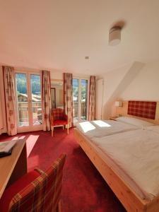 伊瑟尔特瓦尔德斯坦德海滩酒店的卧室配有一张床、一张书桌和窗户。