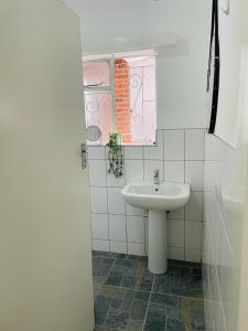 布拉瓦约Remarkable 2-Bed House in Bulawayo的白色的浴室设有水槽和窗户。