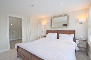 邓斯特布尔Harper Luxe Serviced Apartments Dunstable的卧室配有一张白色大床和镜子