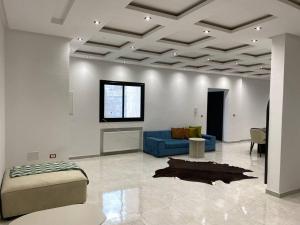 凯鲁万Holy City Gem Modern 3 Bedroom Apartment in Kairwan or Al Qayrawān的客厅配有蓝色的沙发和桌子