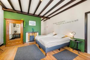 伊普尔卡斯特霍夫提胡奇酒店的一间卧室设有一张床和绿色的墙壁