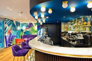 克拉科夫Hotel Ferreus Modern Art Deco的酒吧设有紫色椅子和色彩缤纷的墙壁