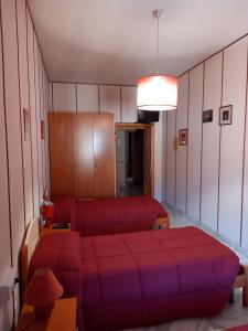 IttiriAffittacamere Su Padru的一间卧室配有红色的床和一张沙发