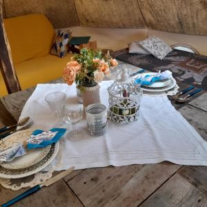 Vielle-TursanTENTE SAFARI LODGE DANS FORET LUXURIANTE的一张桌子上放着白色桌布和鲜花