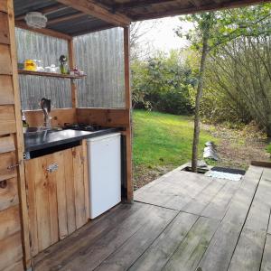 Vielle-TursanTENTE SAFARI LODGE DANS FORET LUXURIANTE的一个带水槽和木甲板的户外厨房