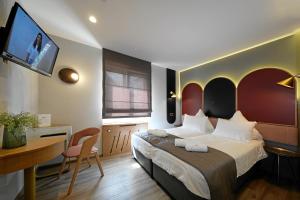 莱茵河畔威尔Hotel-Restaurant Axion的一间卧室配有一张床、一张书桌和一台电视。