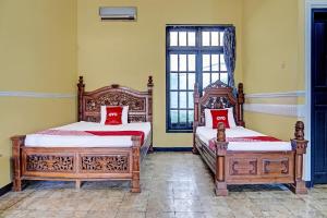CikampekSPOT ON 91798 Hotel Grand Mutiara的一间卧室设有两张床和窗户。