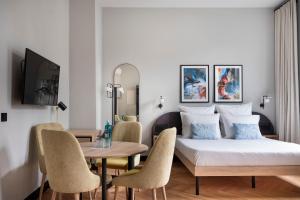 柏林numa I Novela Rooms & Apartments的卧室配有一张床和一张桌子及椅子
