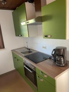 吕本Bungalowdorf Lübben的厨房配有绿色橱柜和水槽