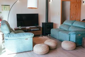 英雄港Quinta do Abacate - Glamping Park的客厅配有沙发、椅子和电视