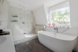 伦敦1st Class Covent Garden Residences for 1st Class Guests的白色的浴室设有浴缸和窗户。