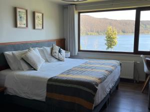 瓦尔迪维亚Hotel Boutique Cutipay的一间卧室配有一张床,享有湖景