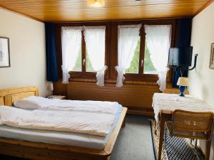 WorbHotel Sternen Worb的一间卧室设有两张床、一张桌子和窗户。