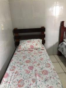 巴拉-杜加萨斯Espaço Magalhães的小卧室配有一张带花卉床罩的床