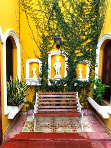 格拉纳达Casa del Agua的坐在黄色建筑前面的长凳