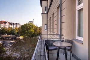 柏林numa I Novela Rooms & Apartments的大楼内的阳台配有两把椅子和一张桌子