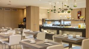 巴塞罗那伊鲁尼奥迪托瑞酒店的一间带桌椅和柜台的餐厅