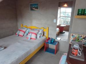 卡兰卡斯Chalé Caiçara的一间卧室配有一张带色彩缤纷枕头的大床