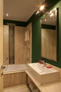比森齐奥营佛罗伦萨500酒店的浴室配有盥洗盆、浴缸和盥洗盆