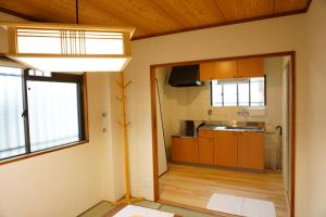 大阪SYOGA A house, next to natural park的一个带木制橱柜和大窗户的厨房