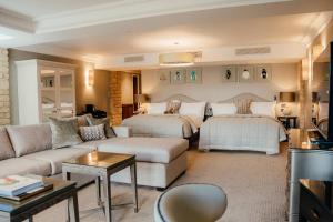 巴格肖特Pennyhill Park Hotel and Spa的一间带两张床和一张沙发的客厅