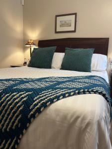 达克斯福德John Barleycorn的一张带蓝色和白色毯子的大床