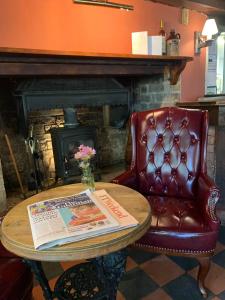 达克斯福德John Barleycorn的一张桌子、报纸和一把带壁炉的椅子