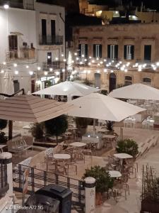奥斯图尼La Chicca di C.Cavour的户外庭院在晚上配有桌子和遮阳伞