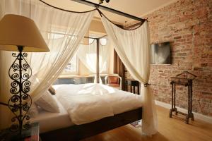 华沙欧迪南卡安眠公寓的一间卧室设有天蓬床和砖墙