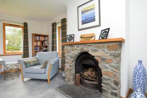WhitehouseKennacraig Lodge的客厅设有石制壁炉和椅子