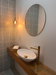 查韦斯Barros' House的浴室设有水槽和镜子,位于柜台上