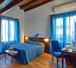 切法卢拉普露米丽雅酒店的一间卧室配有蓝色的床和桌椅