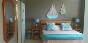 莫塞尔湾Bienvenue Self Catering的卧室配有一张床,墙上挂着2艘帆船