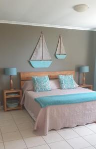 莫塞尔湾Bienvenue Self Catering的卧室配有一张壁挂着两张帆的床铺