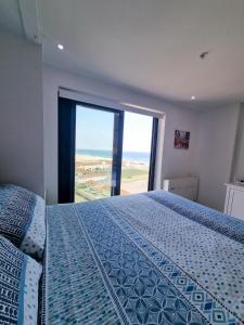 直布罗陀Brand New Top Floor Studio - The Hub Gibraltar - Self Catering的一间卧室设有一张床和一个大窗户