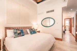 Buena VistaGolf View Apt at Casa De Campo的卧室配有白色的床和镜子