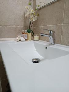 PomaricoMatalena的白色浴室水槽,配有水龙头和鲜花