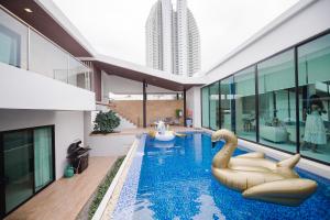 纳仲天Movenpick Pool Villa by Hello Pattaya的一座建筑物内一座带天鹅的游泳池