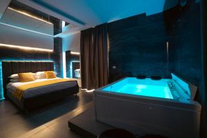 夸利亚诺Intimity Luxury Rooms的一间卧室配有一张床和一个浴缸