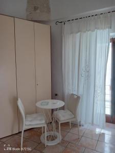 奥斯图尼La Chicca di C.Cavour的客房设有桌子、两把椅子和窗户。